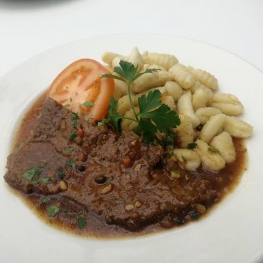 Čebulna bržola v čebulni omaki, kruhova rezina, solata
